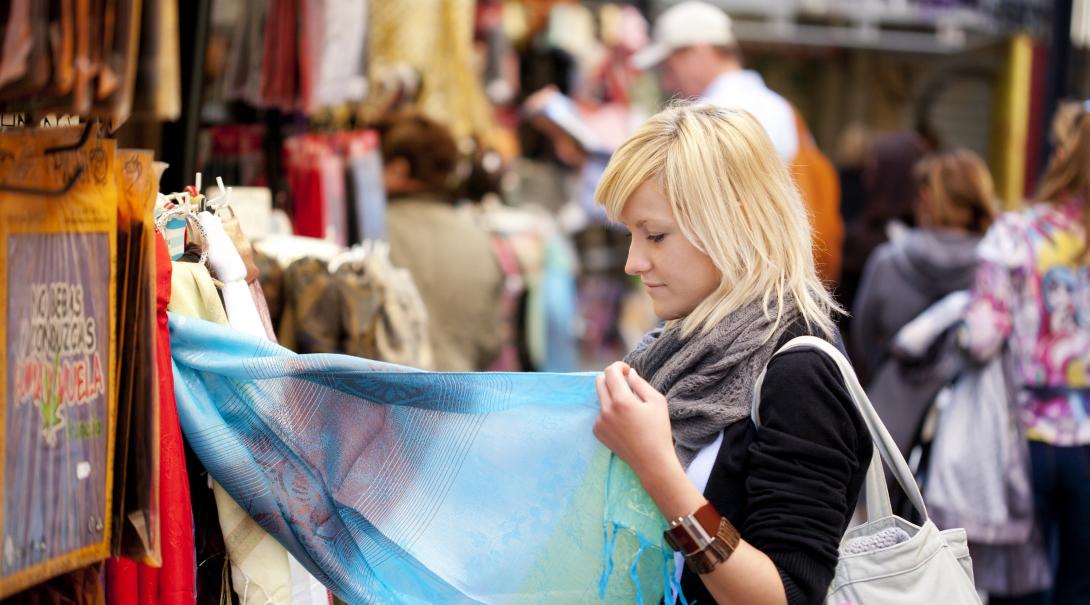 A participant explores a local market as part of her ethical consumerism project abroad. Woman learns about ethical consumerism on a trip abroad.
